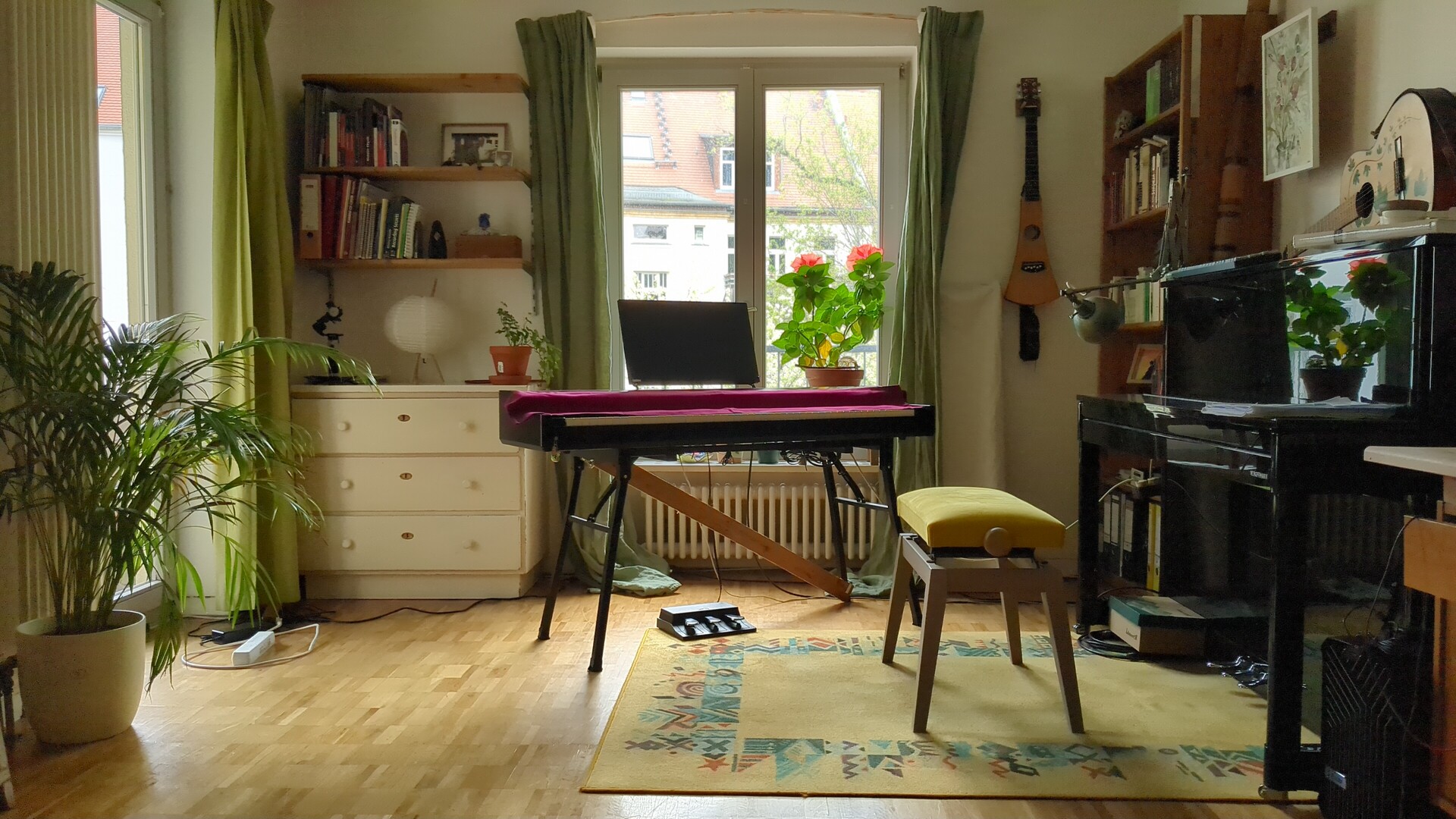 Grand piano bathed in natural light, surrounded by books and lush greenery.