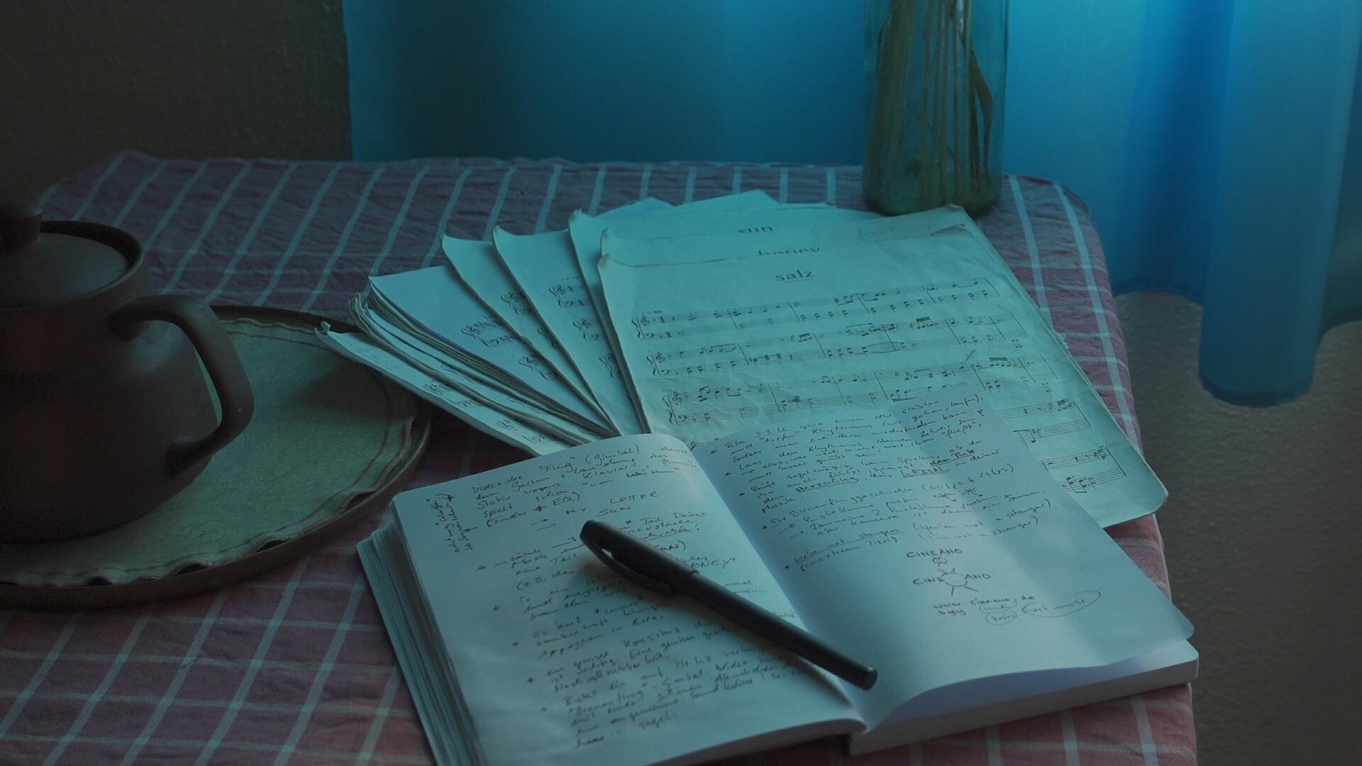 A composition of sheet music and handwritten notes, symbolizing musical and artistic creation.