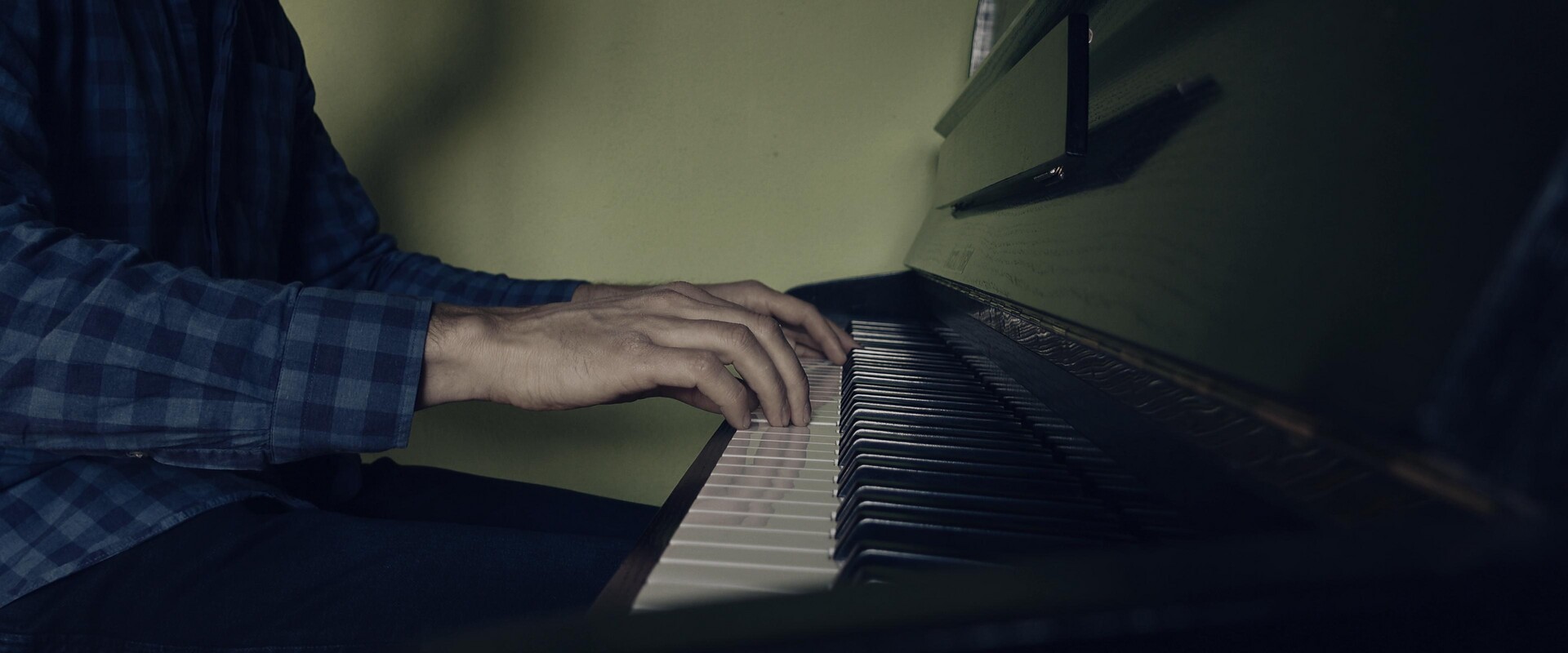 Hands poised over the piano keys, capturing the moment of musical creation.